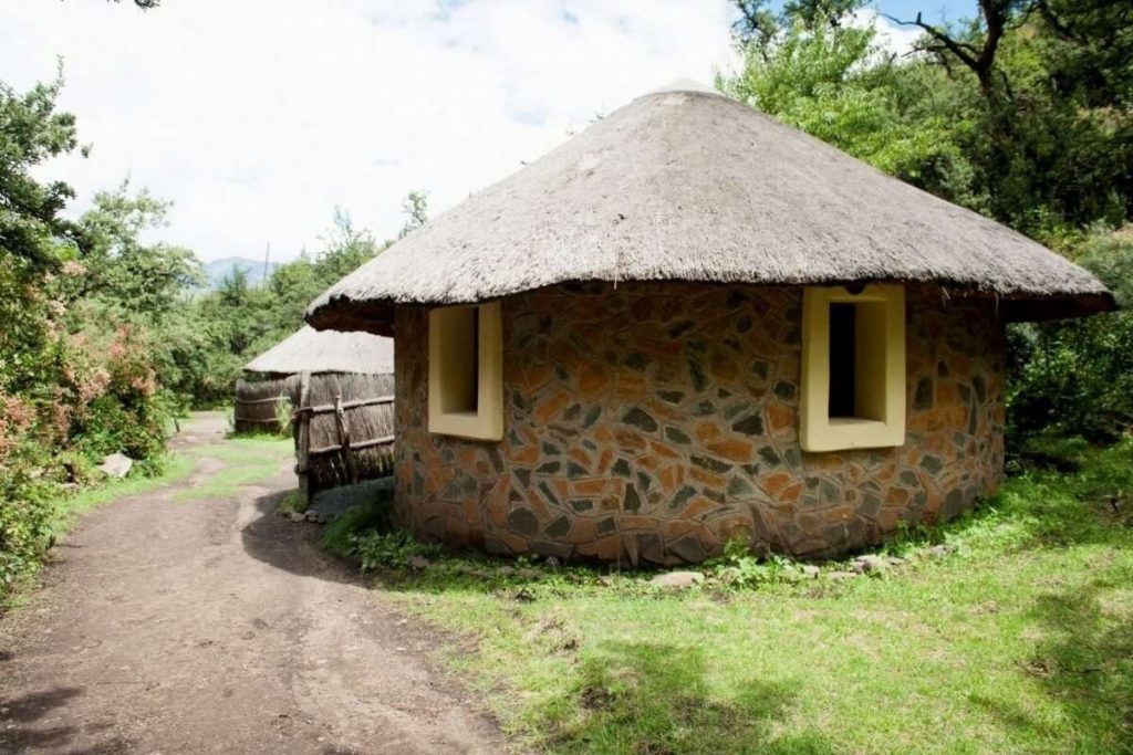 Round stone Riverside Hut with a thatched roof at Maliba